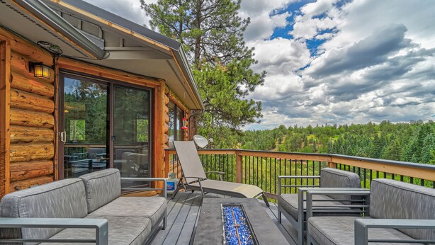 A wooden deck with outdoor seating and a fire feature. - Bakers Creek (Woodland Park)