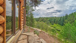 A log cabin with a stone pathway leading to a forested area. - Bakers Creek (Woodland Park)