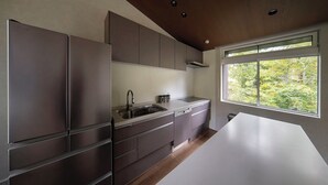 Una cucina moderna con elettrodomestici in acciaio inossidabile, un'ampia finestra vista su un'area verde e un design minimalista.