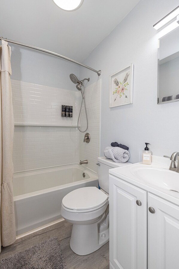 A bathroom with a bathtub, toilet, and sink.