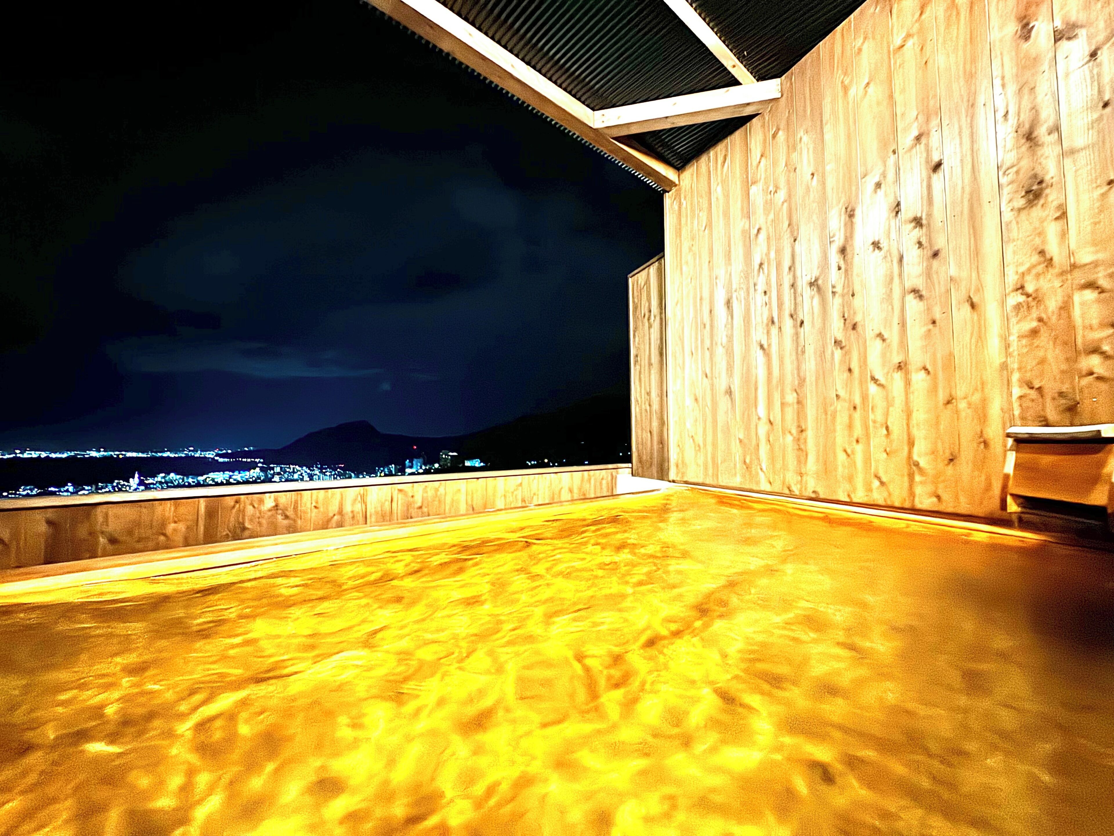 A wooden deck with a view of a cityscape at night.