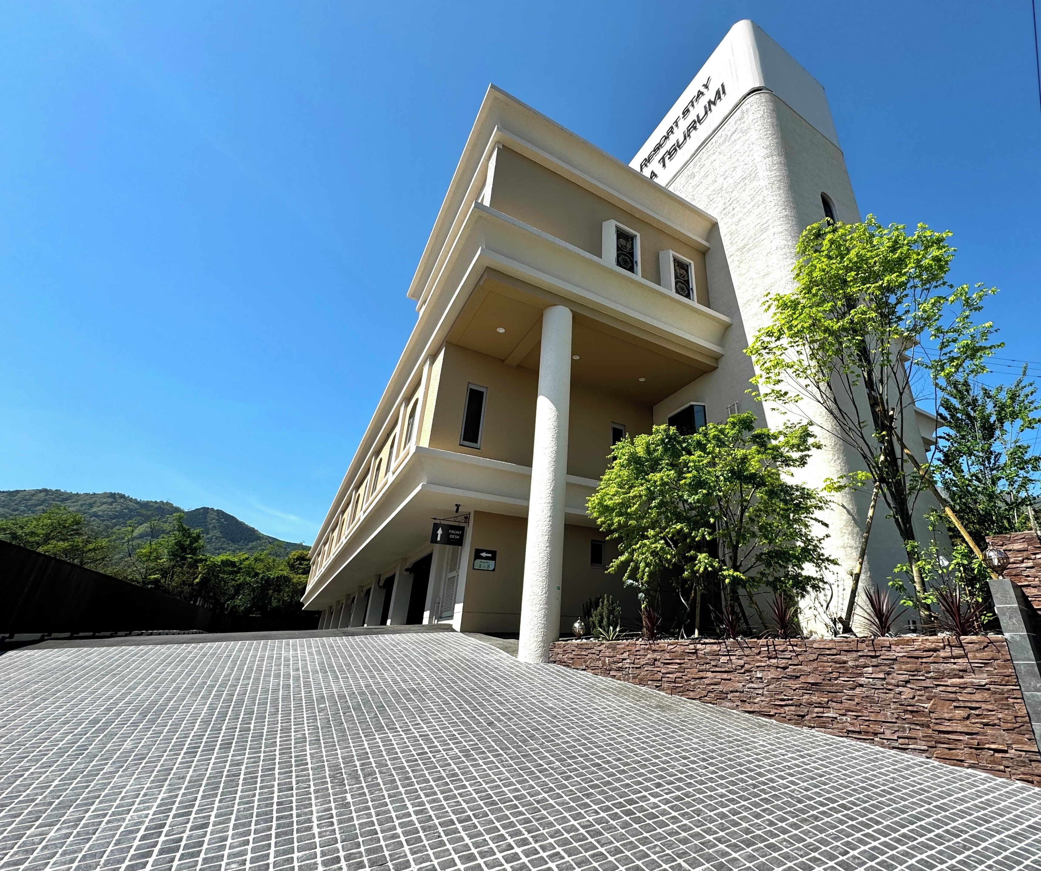 Ein Gebäude im modernen Architekturstil, mit einem markanten Turm und einer flachen Dachfläche.
