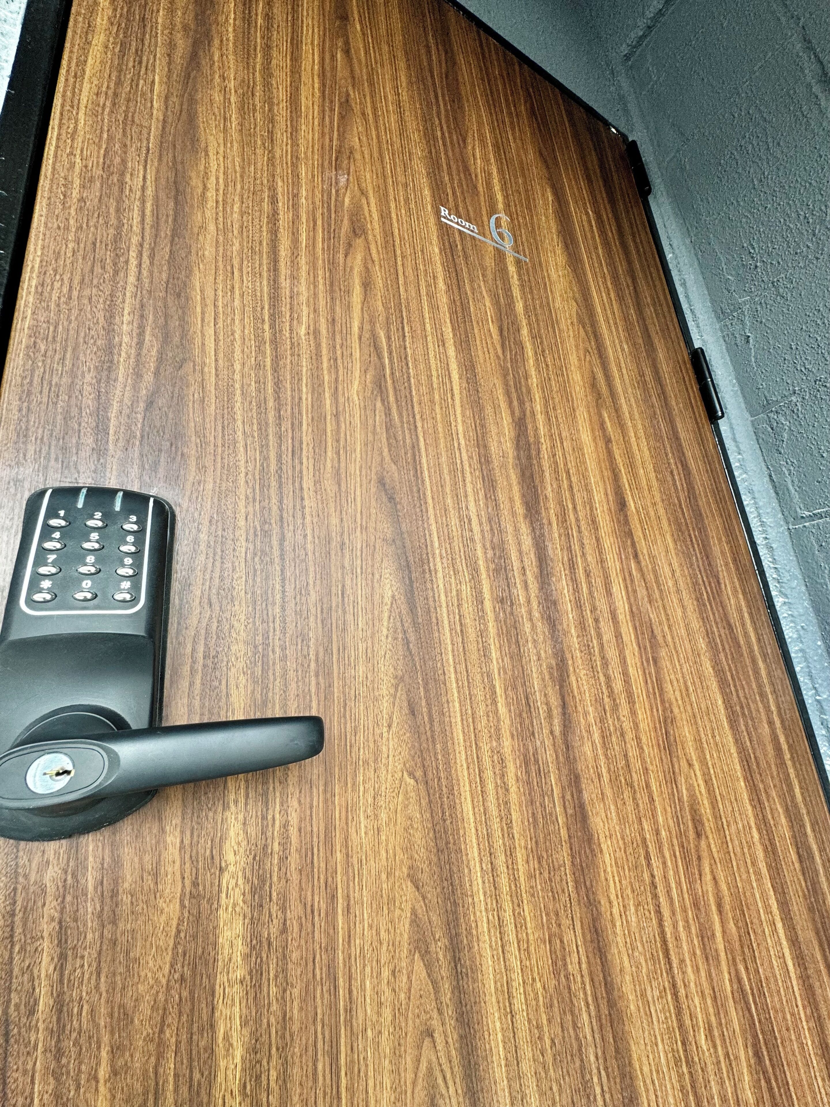 A wooden door with a keyhole and a key inserted.