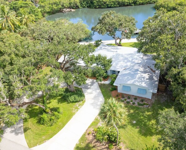 A residential property with a house, a driveway, and a lake. - Live Oak on The Indian River (Vero Beach)