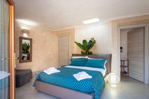 A bedroom with a bed, bedside table, and a potted plant. - Tenuta Bouganville With Garden And Pool, Carpignano Salentino, Italy (Carpignano Salentino)