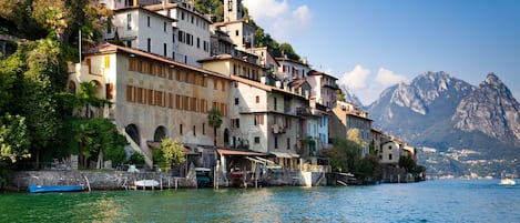 A coastal town with buildings built along the water's edge, featuring balconies and terraces.