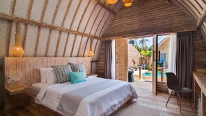 Een slaapkamer met een groot bed, houten plafond en uitzicht op een zwembad en terras.