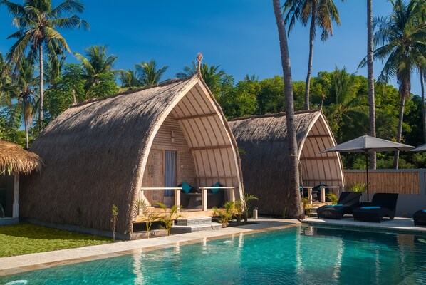 Una piscina al aire libre, sillones reclinables de piscina
