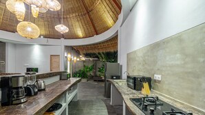 A modern kitchen with a curved ceiling, built-in appliances, and a central island. - Brand New Luxury 3BR Villa Ethnic Ubud 3 (Ubud)