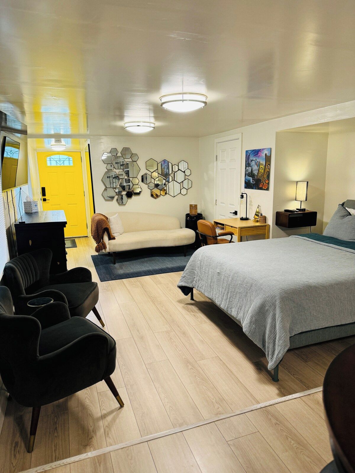 Una habitación de hotel con cama, sofá, escritorio y silla.