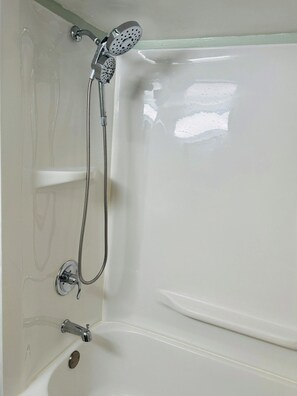 Eine Badewanne mit Duschbrause und Handfaucet.