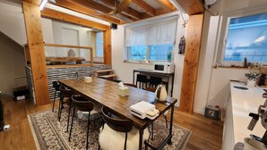 Una cucina accogliente con un tavolo di legno, sedie e un frigorifero.