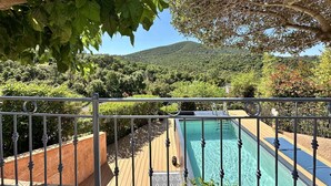 A pool area with a view of a lush, green landscape and a mountain in the background.
