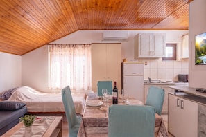A compact living space with a kitchenette, a dining area, and a bedroom. - Studio Apartment Iva Rijeka Suburbs (Rijeka)