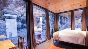 Une chambre moderne avec un grand lit, une table en bois et une chaise.