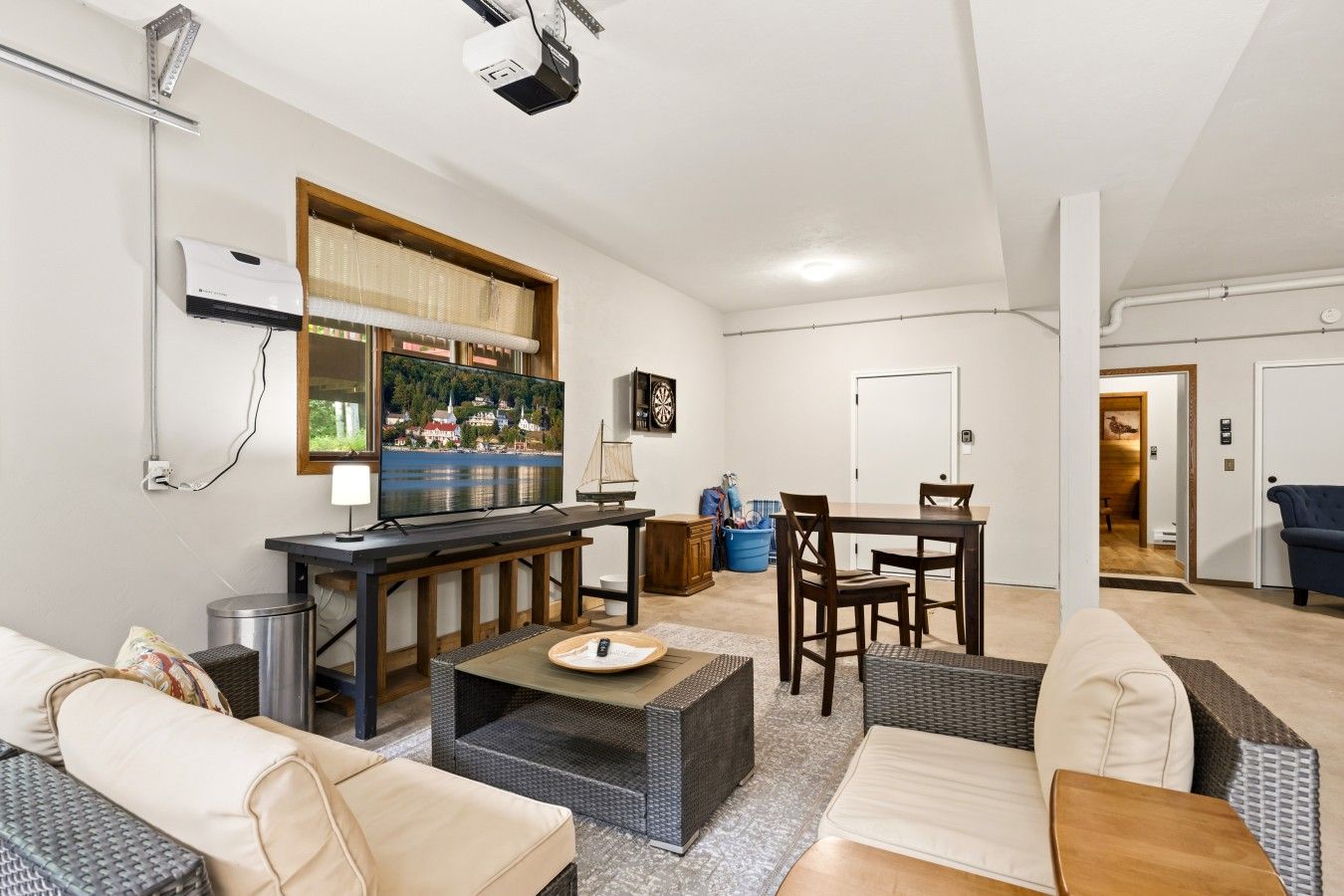 A modern living room with a flat-screen TV, a dining area, and a bar area.