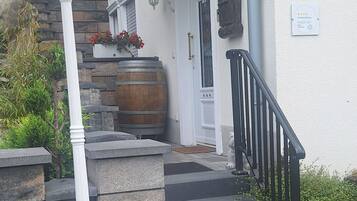 Une entrée d’immeuble avec un escalier, un lampadaire blanc et une plaque portant le numéro « 29 ».
