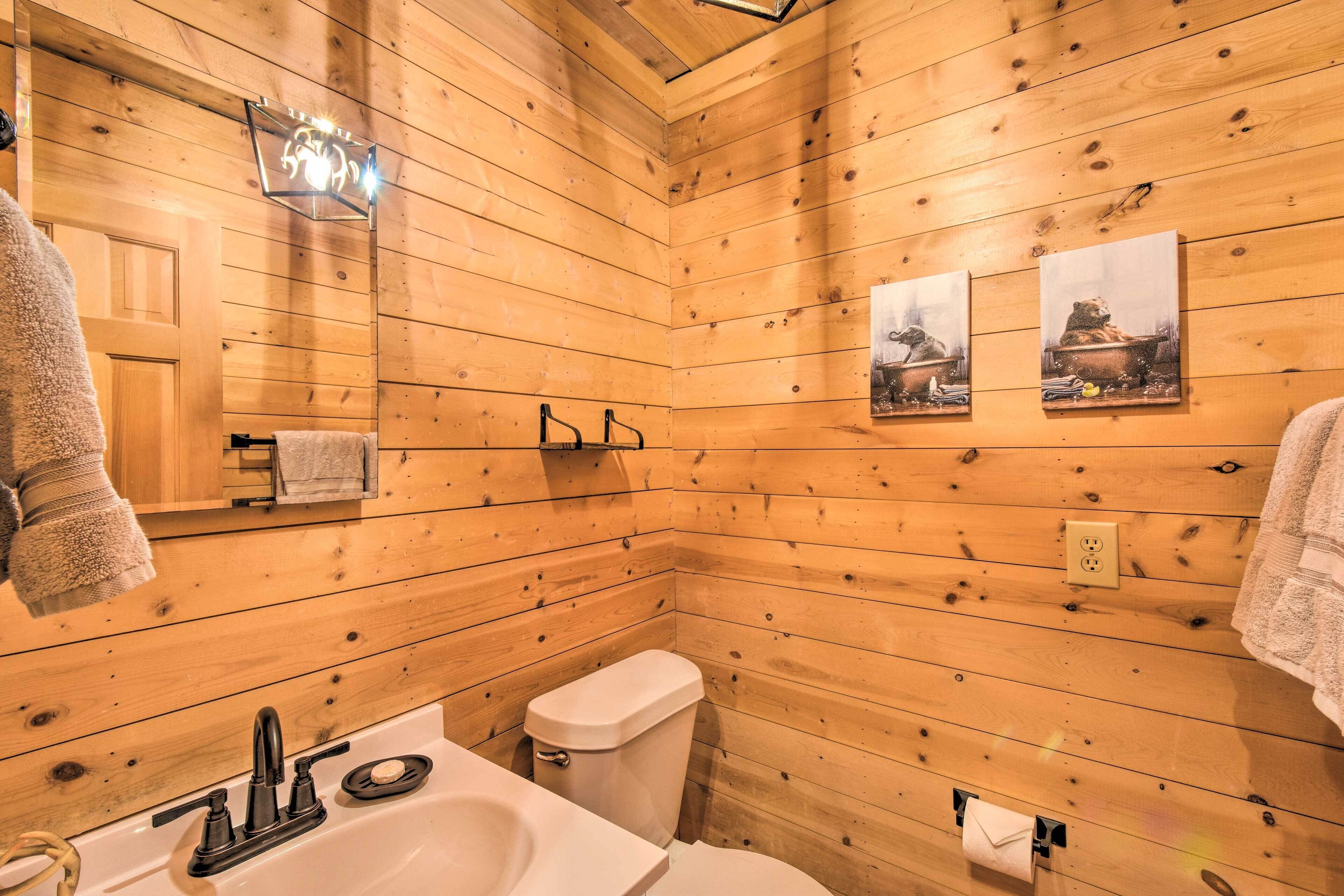 Un baño con paneles de madera, un lavabo, un inodoro y un perchero para toallas.