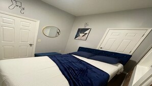 A bedroom with a bed, a round mirror, and a door. - Brick City Dreams  A minute away from The Prudential Center! 4 mins from NJ PAC! (Newark)