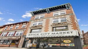 A brick building with a storefront named Brick City Market, offering smoothies, salads, sandwiches, and burgers. - Brick City Dreams  A minute away from The Prudential Center! 4 mins from NJ PAC! (Newark)