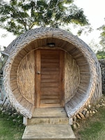 Una estructura circular con una puerta de madera y escalones que la conducen.