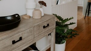 Eine moderne Küche mit weißen Schränken, einer Holztischplatte und einem Blumentopf.