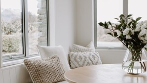 Ein gemütlicher Sitzbereich mit einem runden Holztisch und einer Blumenvase.