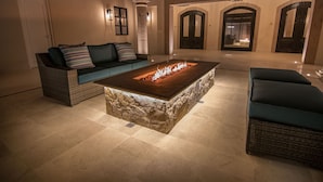 A cozy living area with a stone coffee table, a sofa with striped cushions, and a lounge chair.