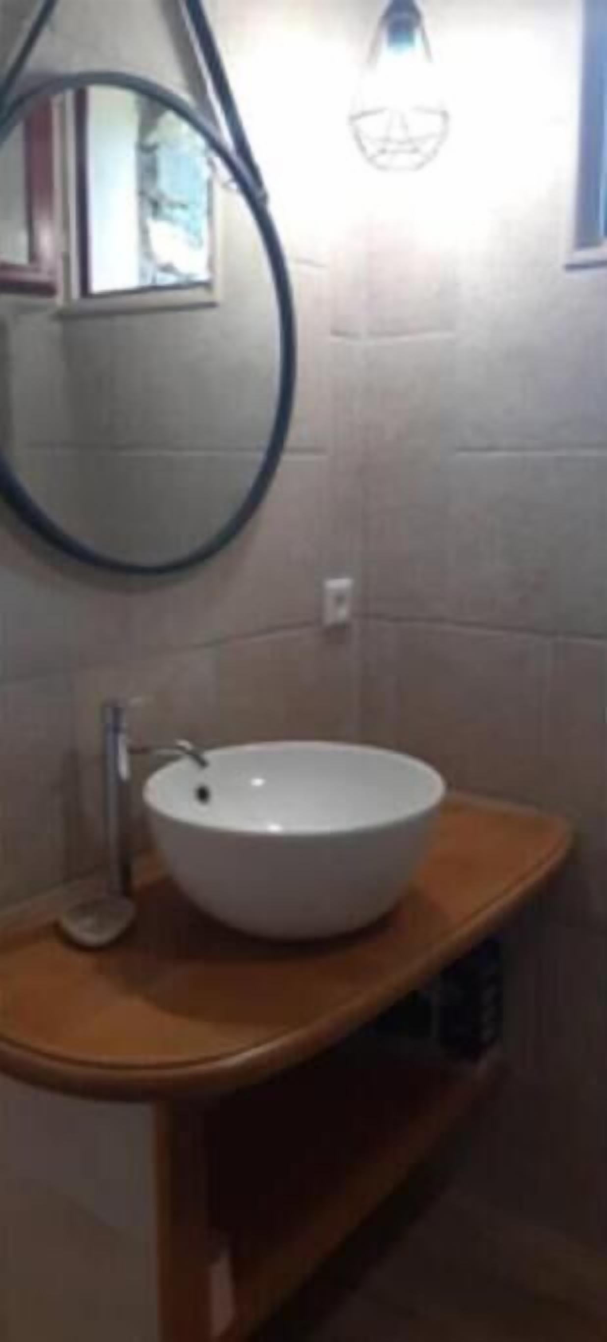 A bathroom with a white sink, a mirror, and a towel rack.