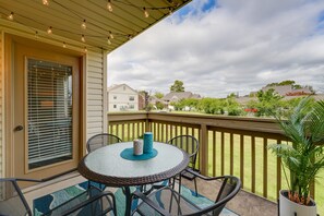 A covered patio with a round table and chairs, a potted plant, and a view of the neighborhood. - Branson Family-Friendly Condo w/ Golf Package! (Branson)