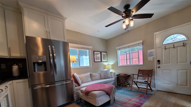 A modern kitchen with a stainless steel refrigerator, a ceiling fan, and a colorful rug. - Waypoint Cottage, one block from the beach! (San Diego)