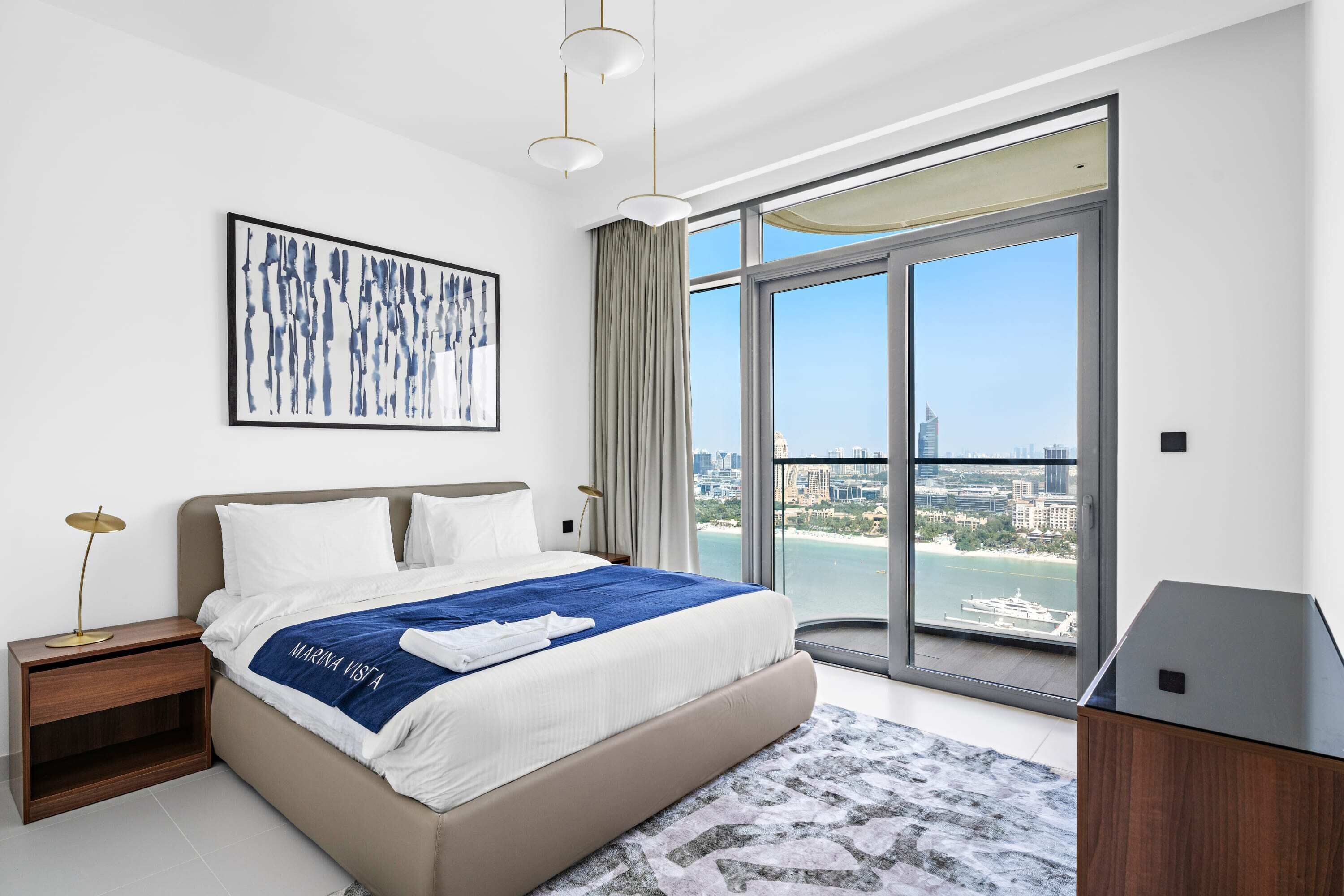 Een moderne hotelkamer met een groot bed, stadszicht en een minimalistisch design.