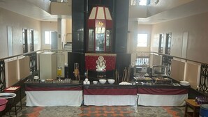 Vestíbulo de hotel con un altar central, una mesa de buffet y un suelo con diseño.