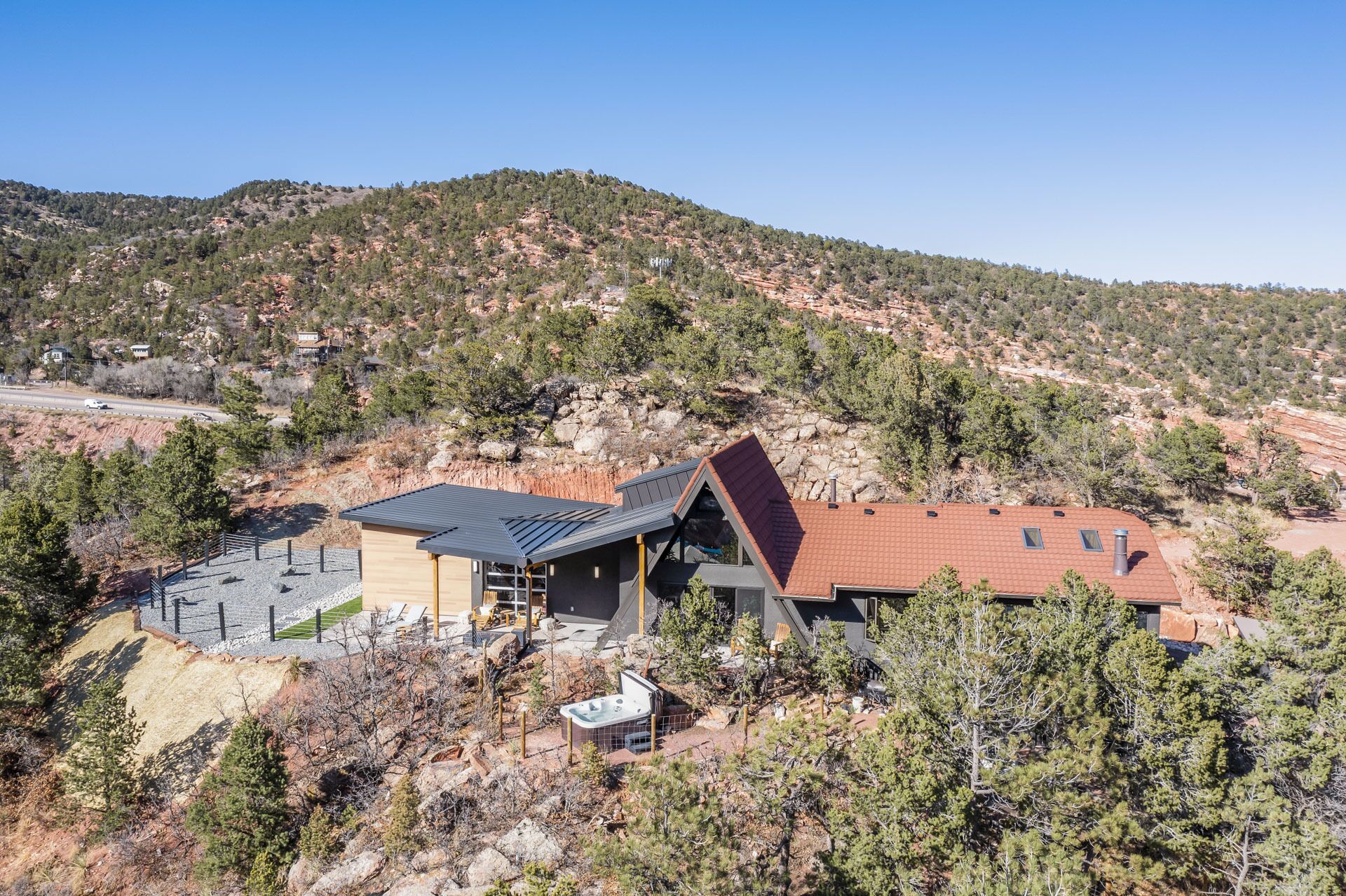 A modern house with a sloped roof, surrounded by a mountainous landscape.