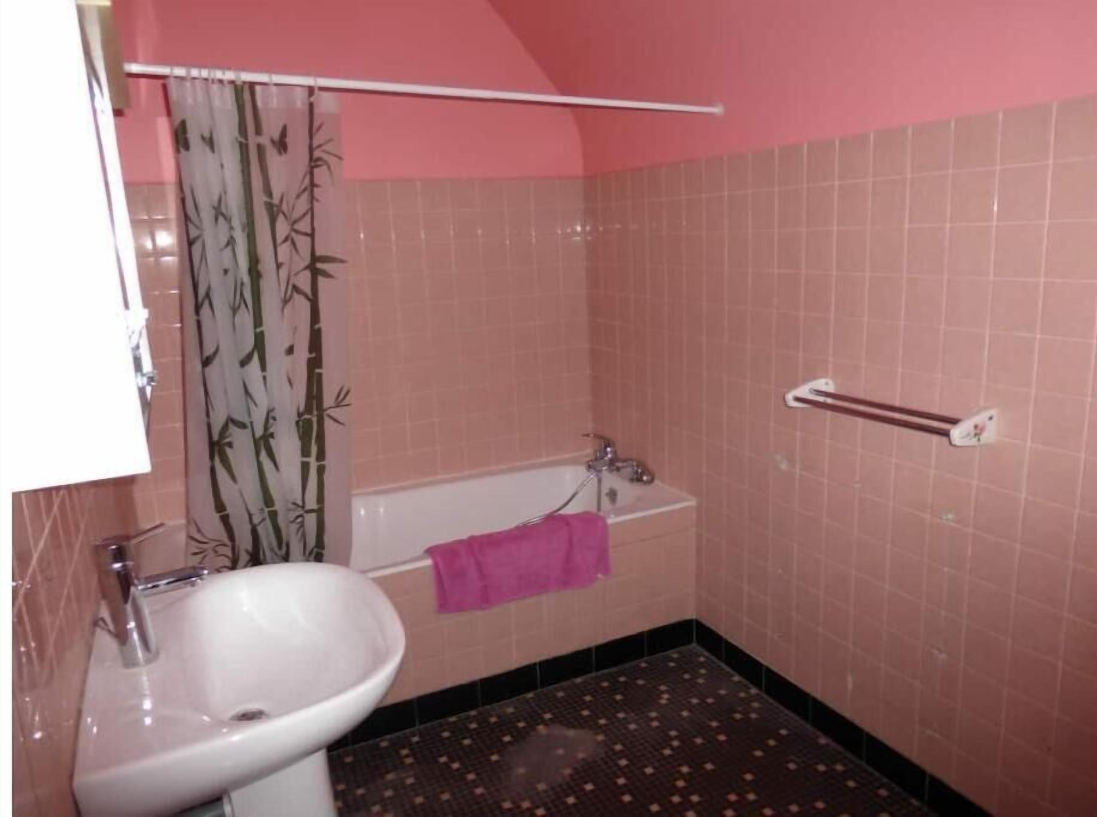 A bathroom with a sink, a bathtub, and a shower curtain.