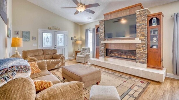 A living room with a fireplace, a television, and comfortable seating. - 0.3 mi. to beach, 4 BR, 3 Bath, sleeps 9, grill, pool table, games, LSV for rent (North Myrtle Beach)