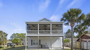 A two-story house with a balcony, a palm tree, and a car parked in the driveway. - 0.3 mi. to beach, 4 BR, 3 Bath, sleeps 9, grill, pool table, games, LSV for rent (North Myrtle Beach)