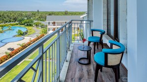 A balcony with a view of a swimming pool and lush greenery.