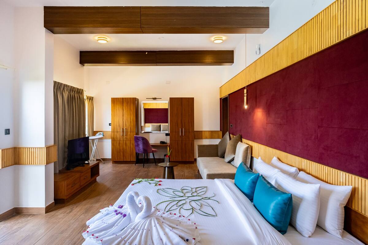 Une chambre d’hôtel avec un grand lit, un bureau, une chaise et un téléviseur.