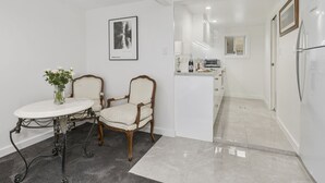 A modern kitchen with white cabinetry, a built-in oven, and a countertop with a toaster. - Sutherland Sunrise - Kingscliff Studio (Tweed)