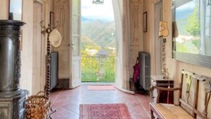 A room with a large window, a fireplace, and a view of a mountainous landscape.