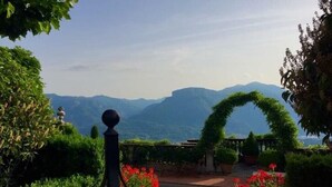 A pool surrounded by lush greenery and a view of distant mountains.
