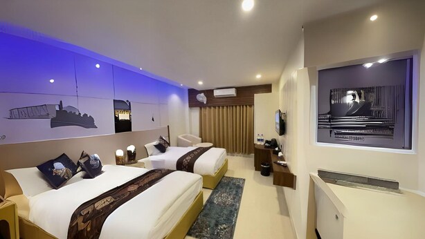 A hotel room with two beds, a desk, a TV, and a large window. - Janaki Star Hotel (Janakpur)