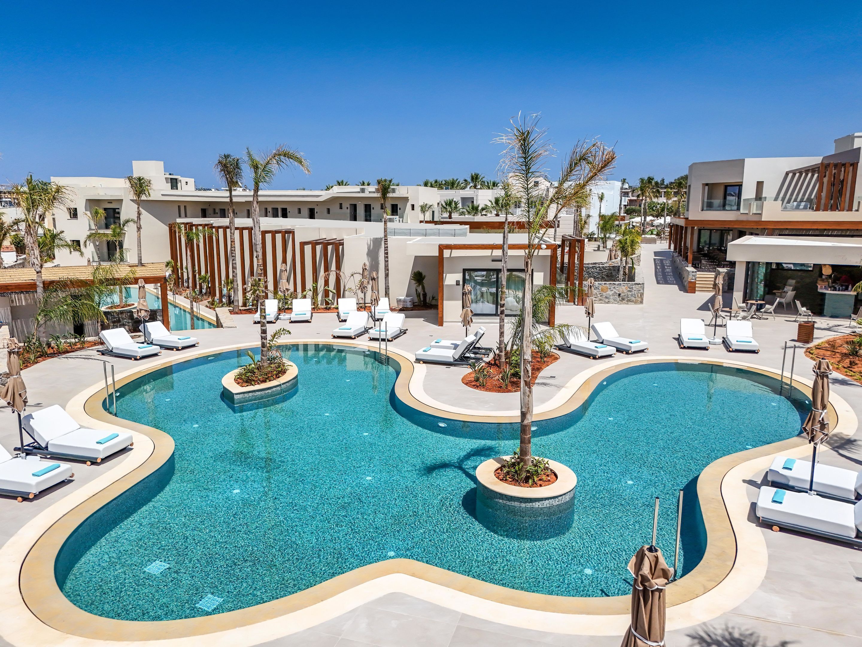 A modern pool area with lounge chairs and palm trees.