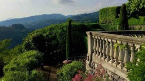 A garden with a stone balustrade overlooking a mountainous landscape.