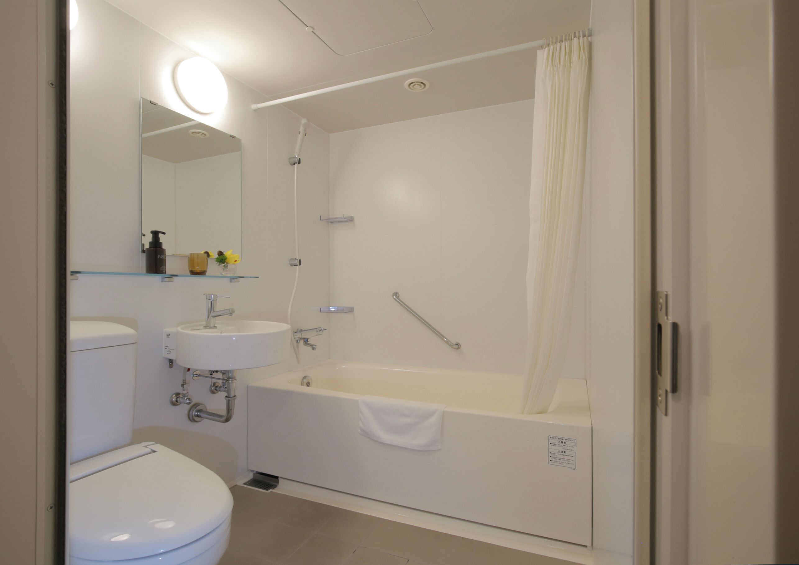 A modern bathroom with a toilet, sink, and bathtub.
