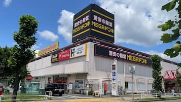 A commercial building with multiple signs, including a prominent 'MEGA' sign, and a parking sign indicating a parking area.