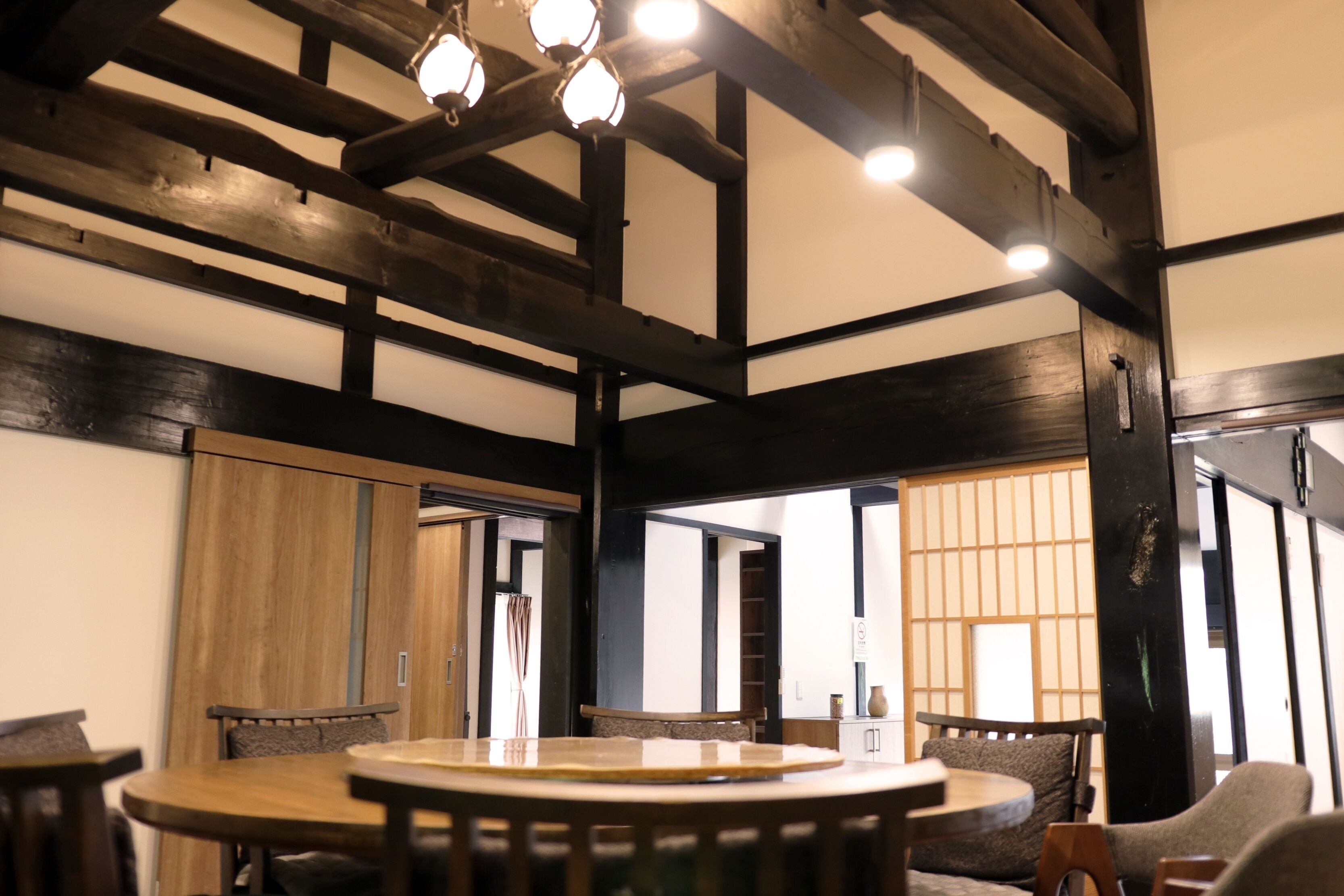 Une pièce de style japonais traditionnel, avec un sol recouvert de tatamis, des poutres en bois et un paravent shoji.