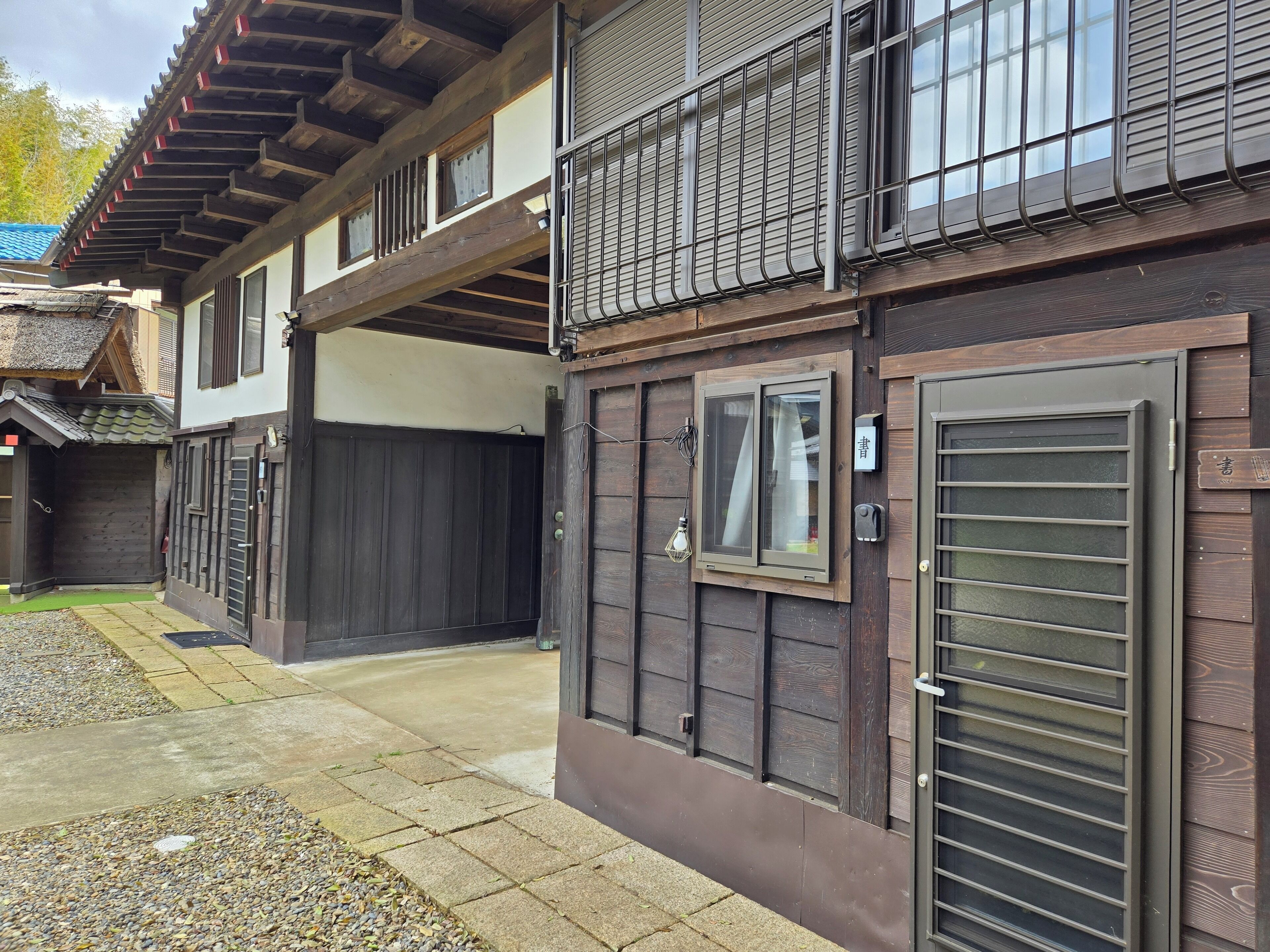 A traditional Japanese building with a wooden exterior, a sliding door, and a small window.
