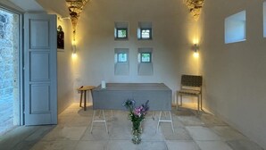 Een kapel met een stenen plafond, een wit altaar en een bank.